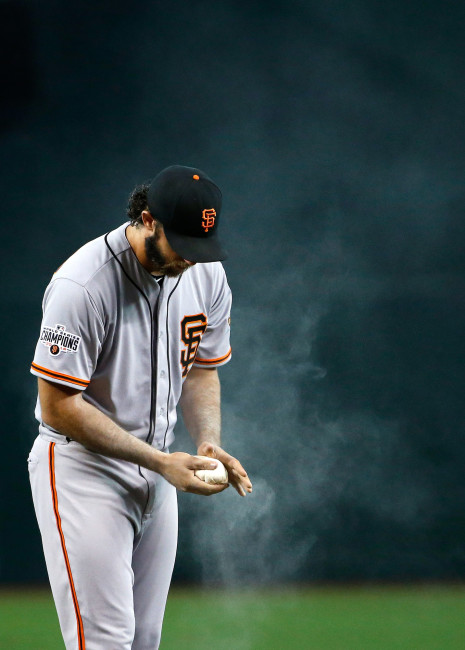 San Francisco Giants pitcher Madison Bumgarner applies rosin to his hand and arm during the first inning of a baseball game against the Arizona Diamondbacks Sunday, July 19, 2015, in Phoenix. (AP Photo/Ross D. Franklin)